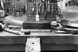 Ein Werkbrett mit verschiedenen Werkzeugen, wie sie in einer Goldschmiede üblich sind.